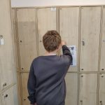 Jeden z uczestników podczas otwierania szafki z zadaniem