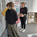 Dwie uczestniczki stoją rozmawiając z prowadzącą