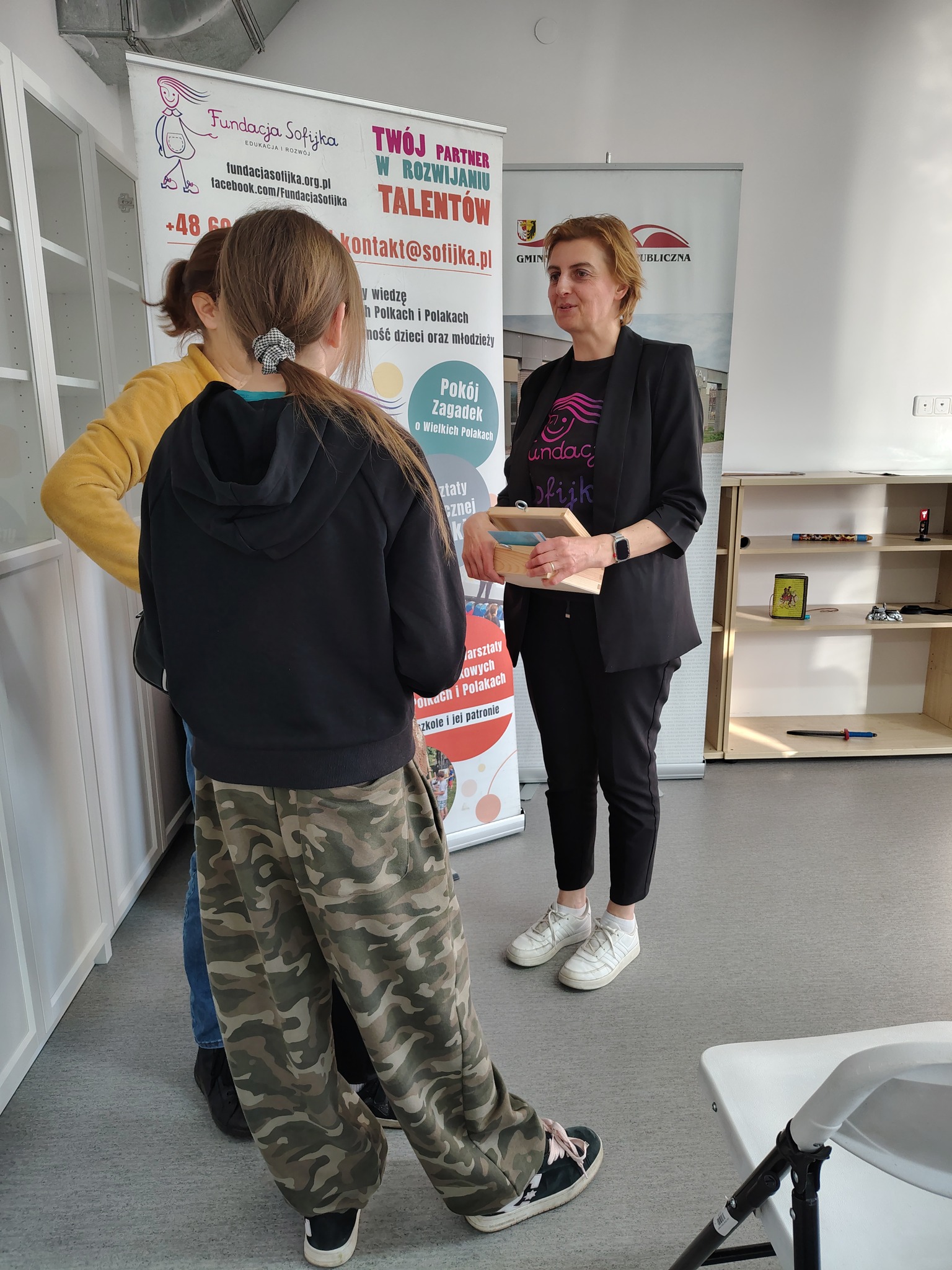 Dwie uczestniczki stoją rozmawiając z prowadzącą