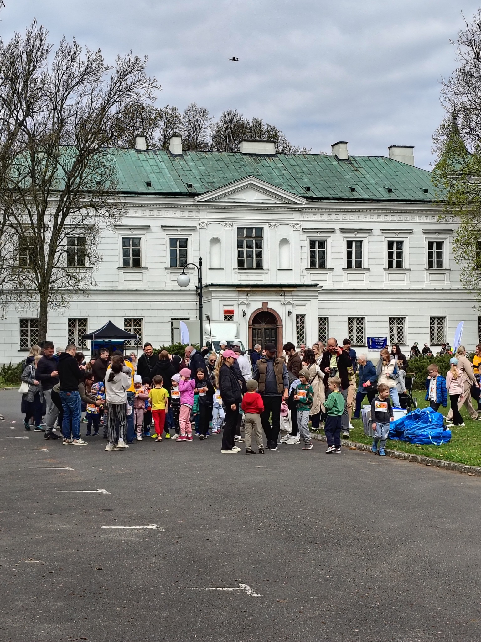 Grupa uczestników biegu Złotych Pszczół na tle pałacu w Falentach