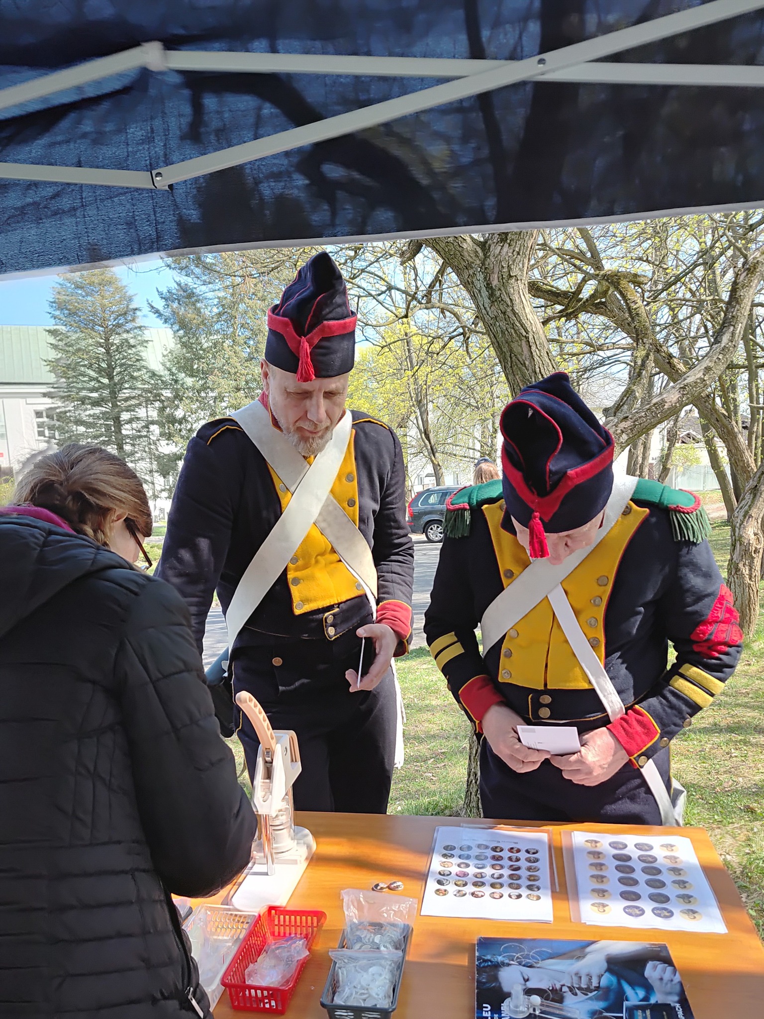Rekonstruktorzy przy stoisku biblioteki czekają na przypinki