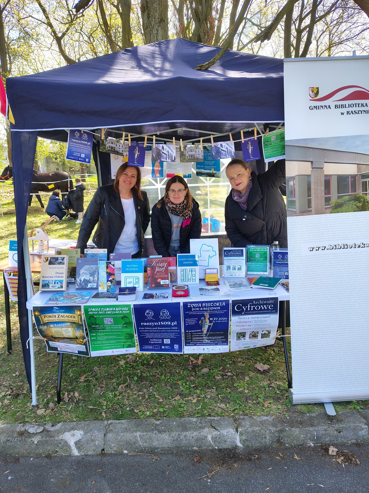 Przedstawicielki biblioteki na stoisku w granatowym namiocie