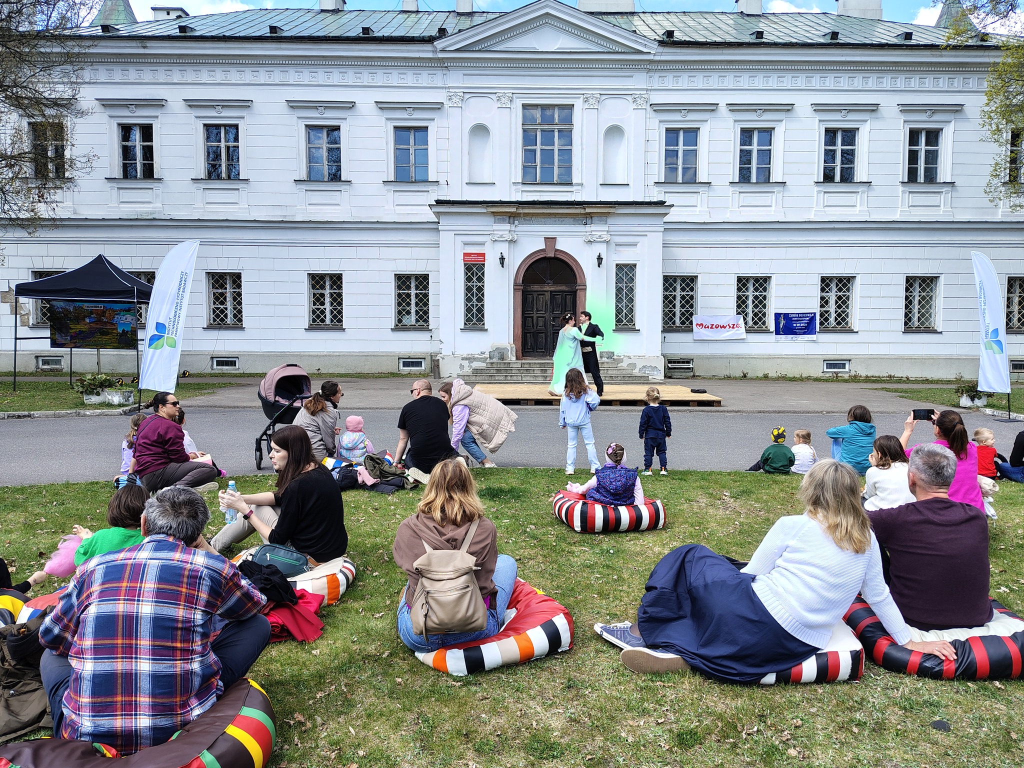 Tancerze podczas tańców dawnych na tle pałacu w Falentach, od tyłu widać zgromadzoną widownię
