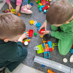 Dzieci podczas zabawy z klockami Lego - widok z góry