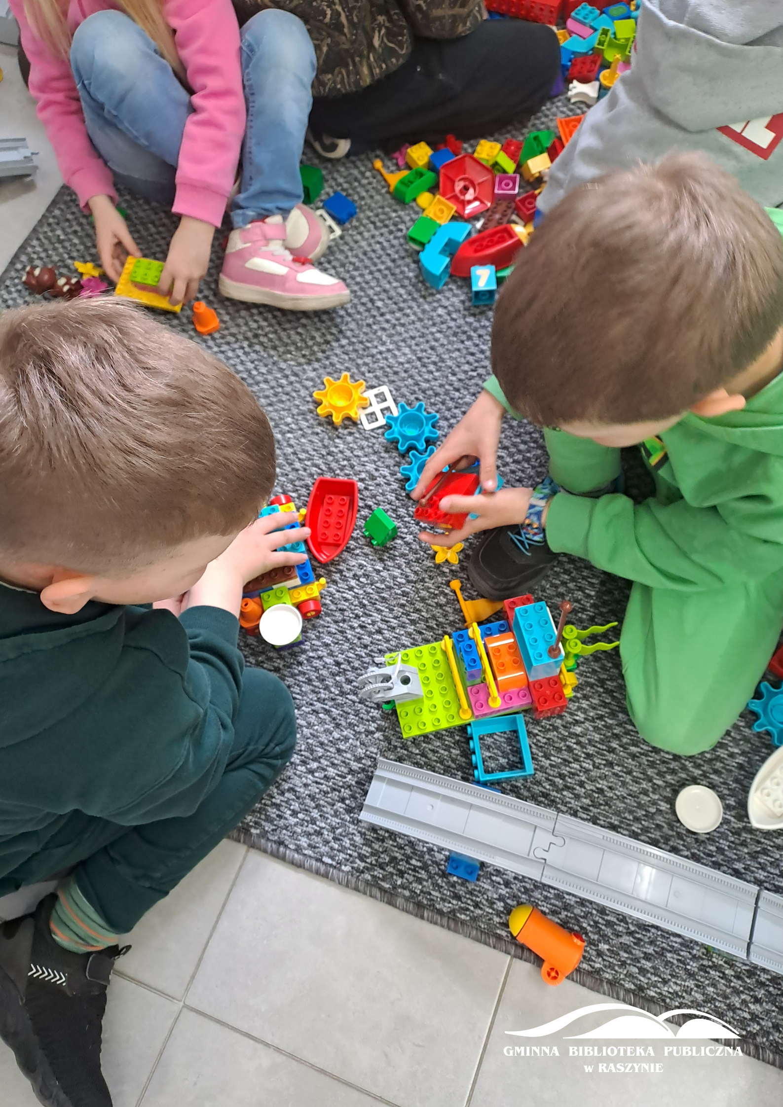 Dzieci podczas zabawy z klockami Lego - widok z góry