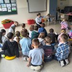 Dzieci i bibliotekarka podczas lekcji bibliotecznej w świetlicy szkolnej