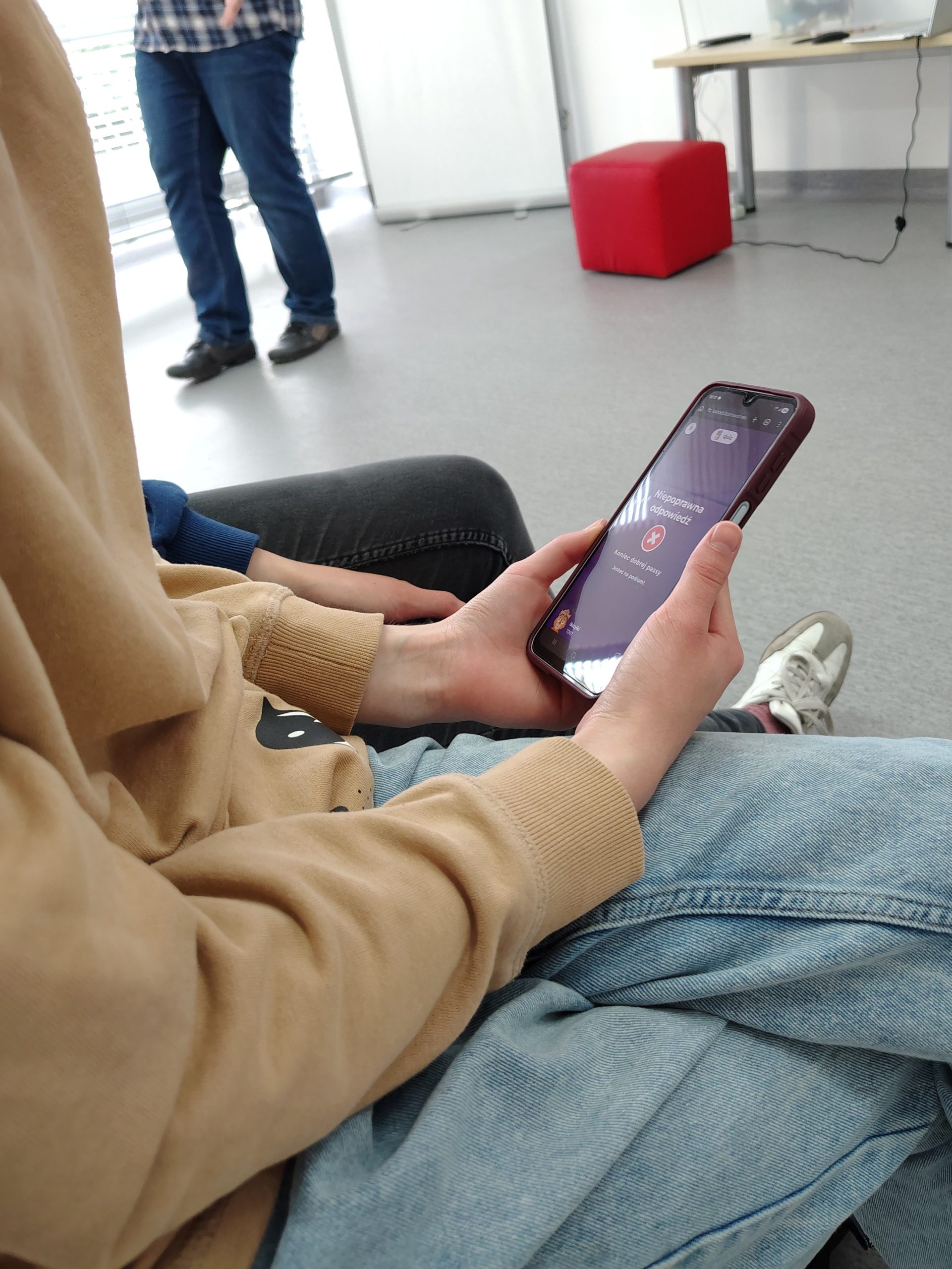 Uczestnik trzyma telefon z quizem