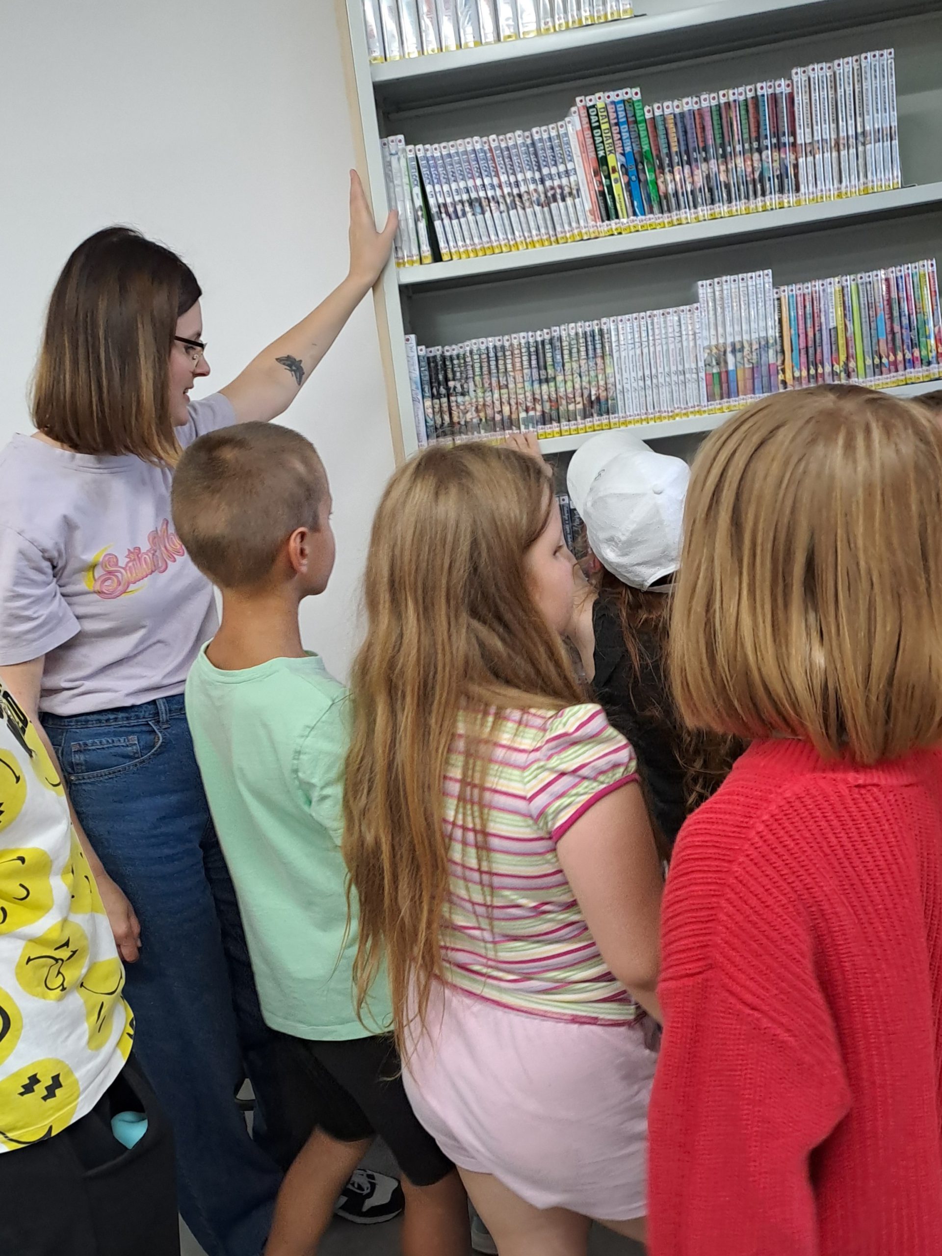 Dzieci oglądają komiksy w dziale z komiksami i mangami