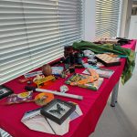 Stoły z przedmiotami związanymi z podróżnikami, m.in. motyle w ramkach
