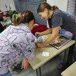 Dwie uczestniczki podczas oglądania zbiorów przez lupy